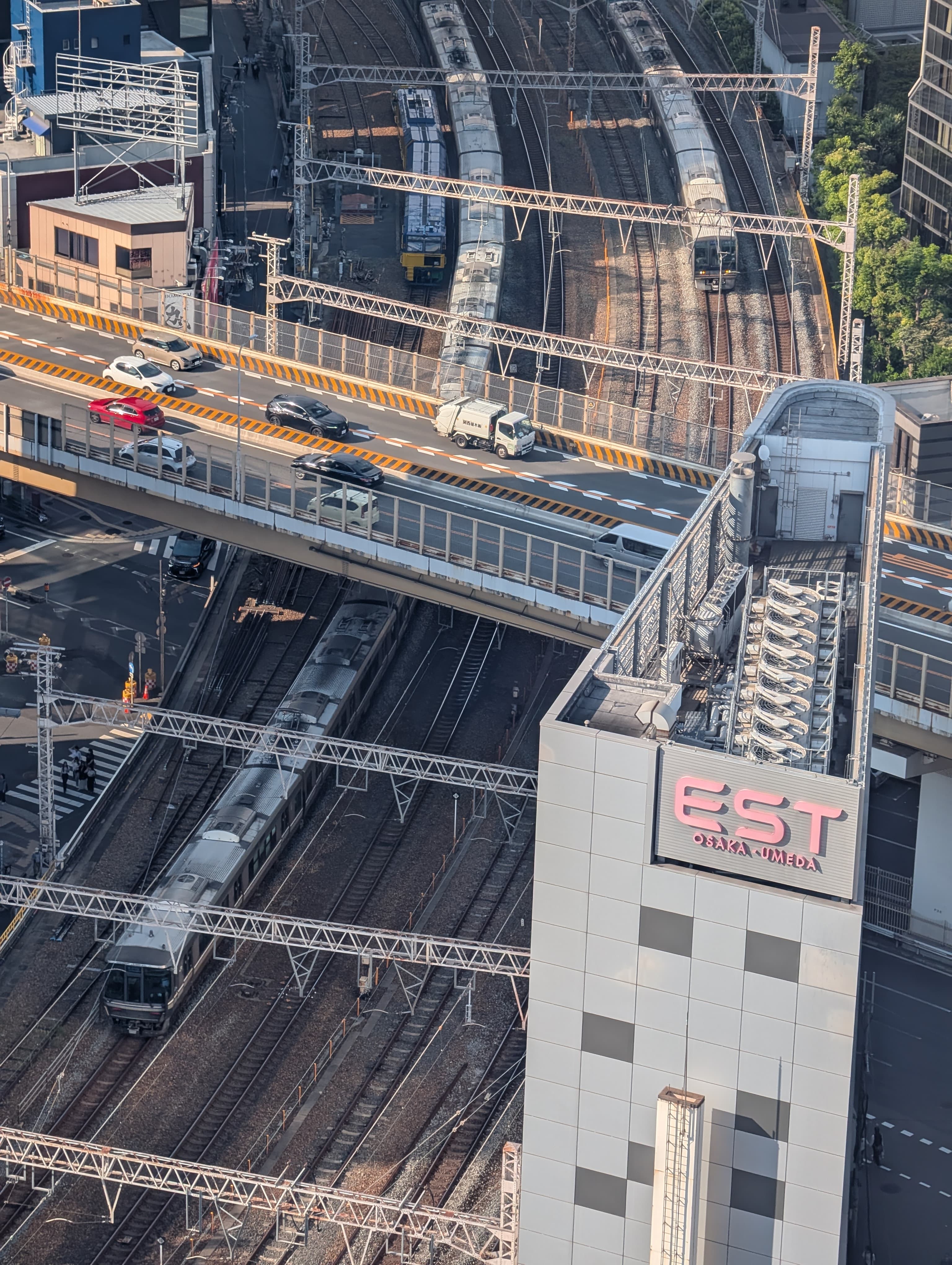 Trains and roads crossing between the buildings in Osaka.