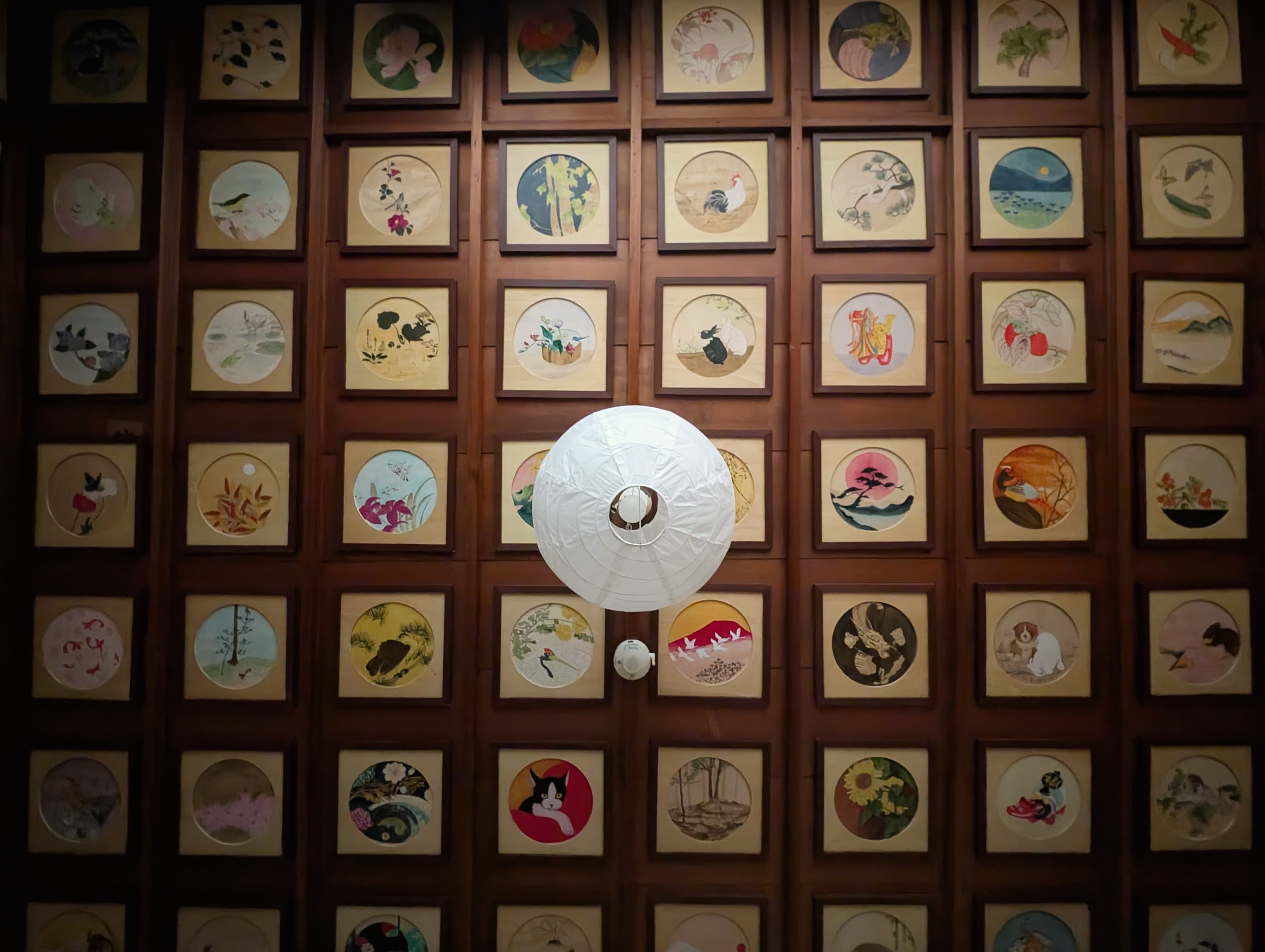 Painted ceiling panels around a hanging paper lantern.